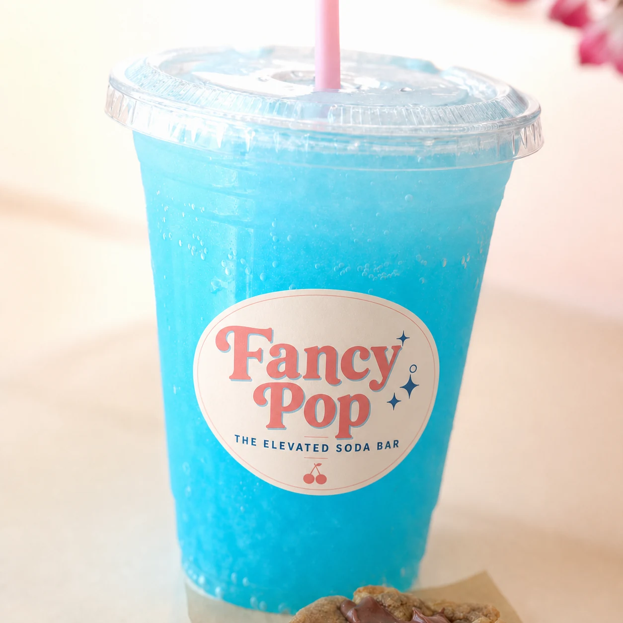 Blue Fancy Pop specialty soda with pink straw and elevated soda bar label
