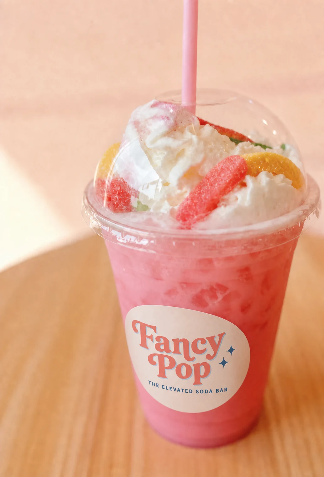 Pink Fancy Pop specialty soda with whipped topping and elevated soda bar label